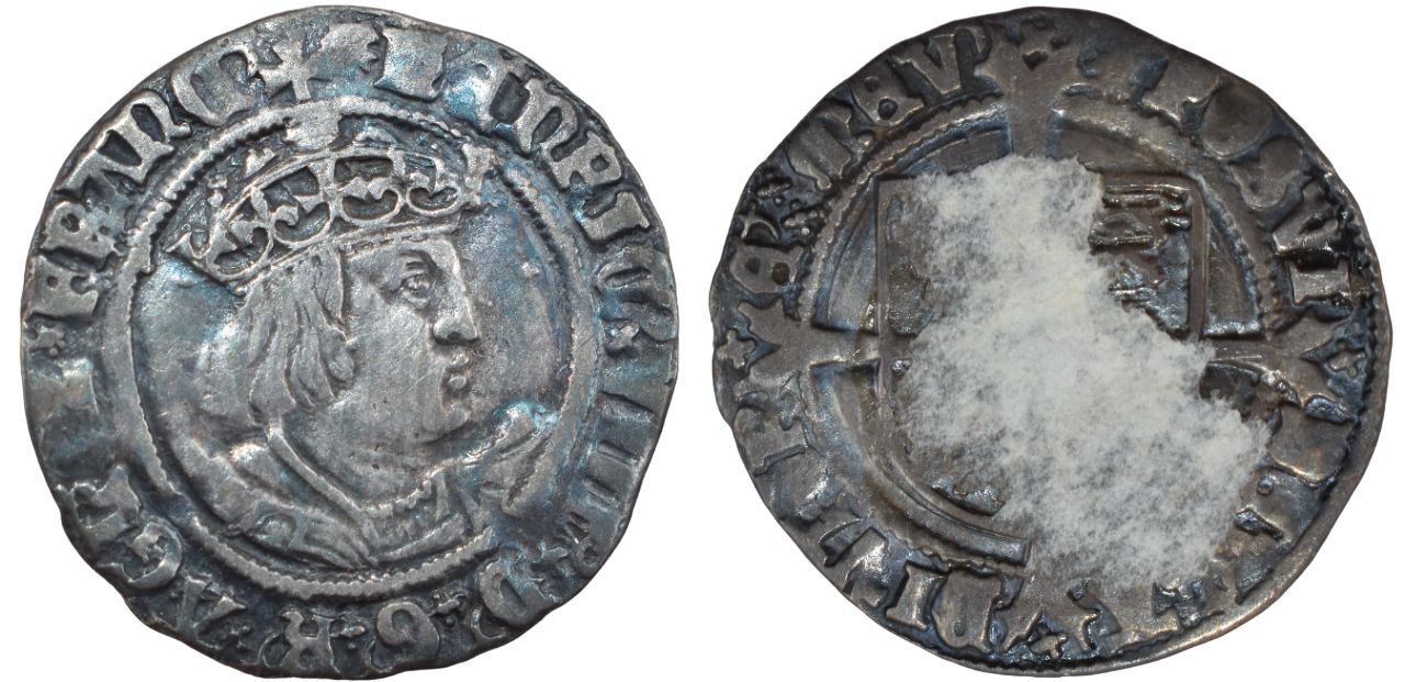 Antique silver coin showing a crowned profile on one side, surrounded by an inscription. The opposite side is worn and partially obscured.