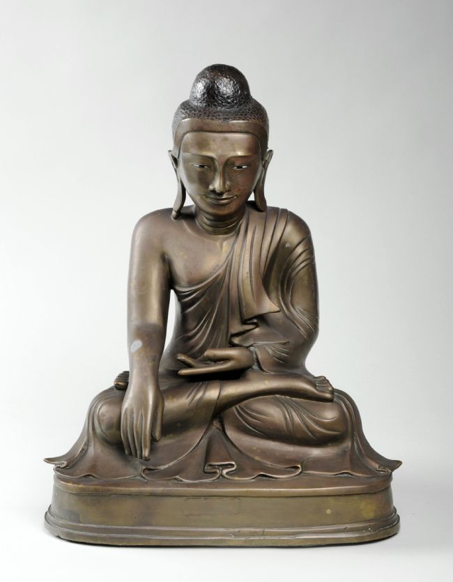 A figurine showing the Buddha in the 'Calling the Earth to Witness' posture, with the right hand pointing down towards the Earth