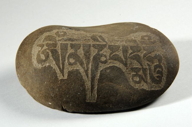 Small stone carved with the Buddhist mantra Om Mani Padme Hum