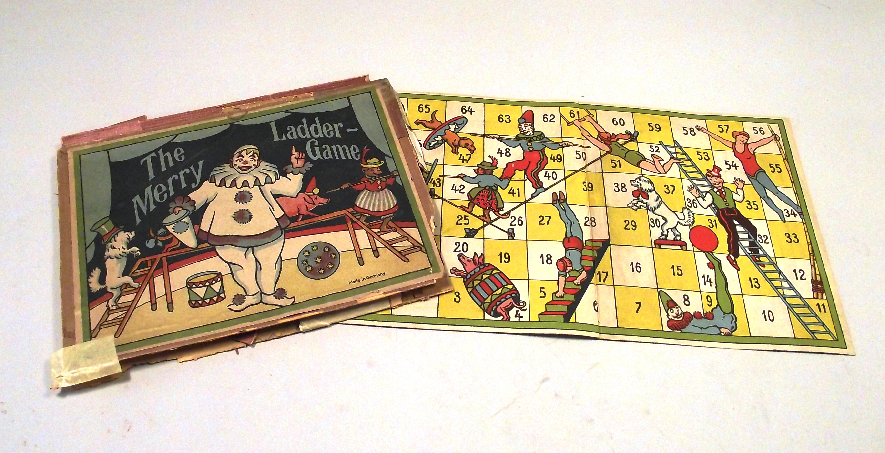 Circus themed Snakes and Ladders with a clown balancing a ball, a tight-rope walker, a pig in a barrel and a dog jumping through a hoop.