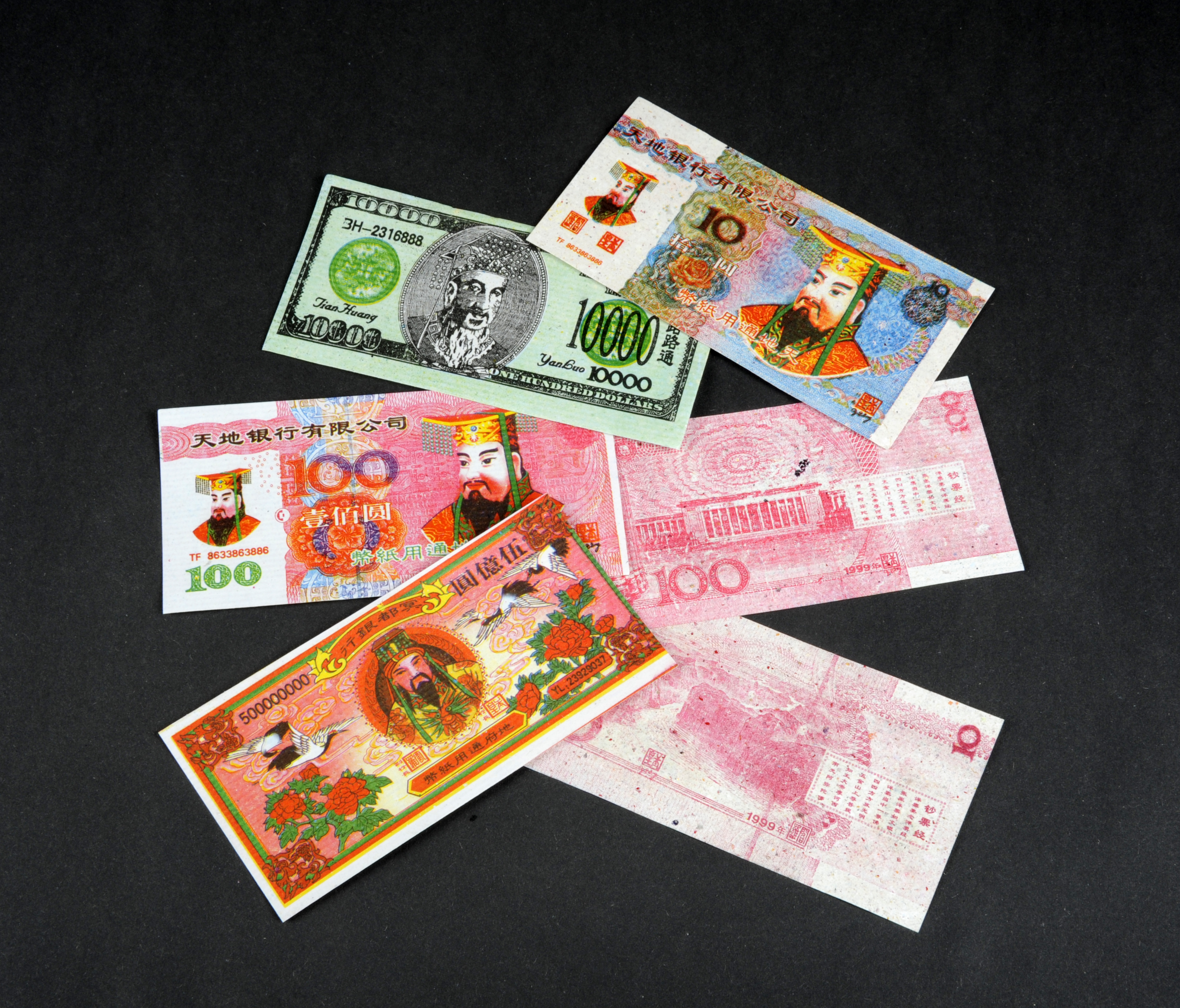 Six imitation Chinese banknotes. They are very brightly coloured with lots of red.