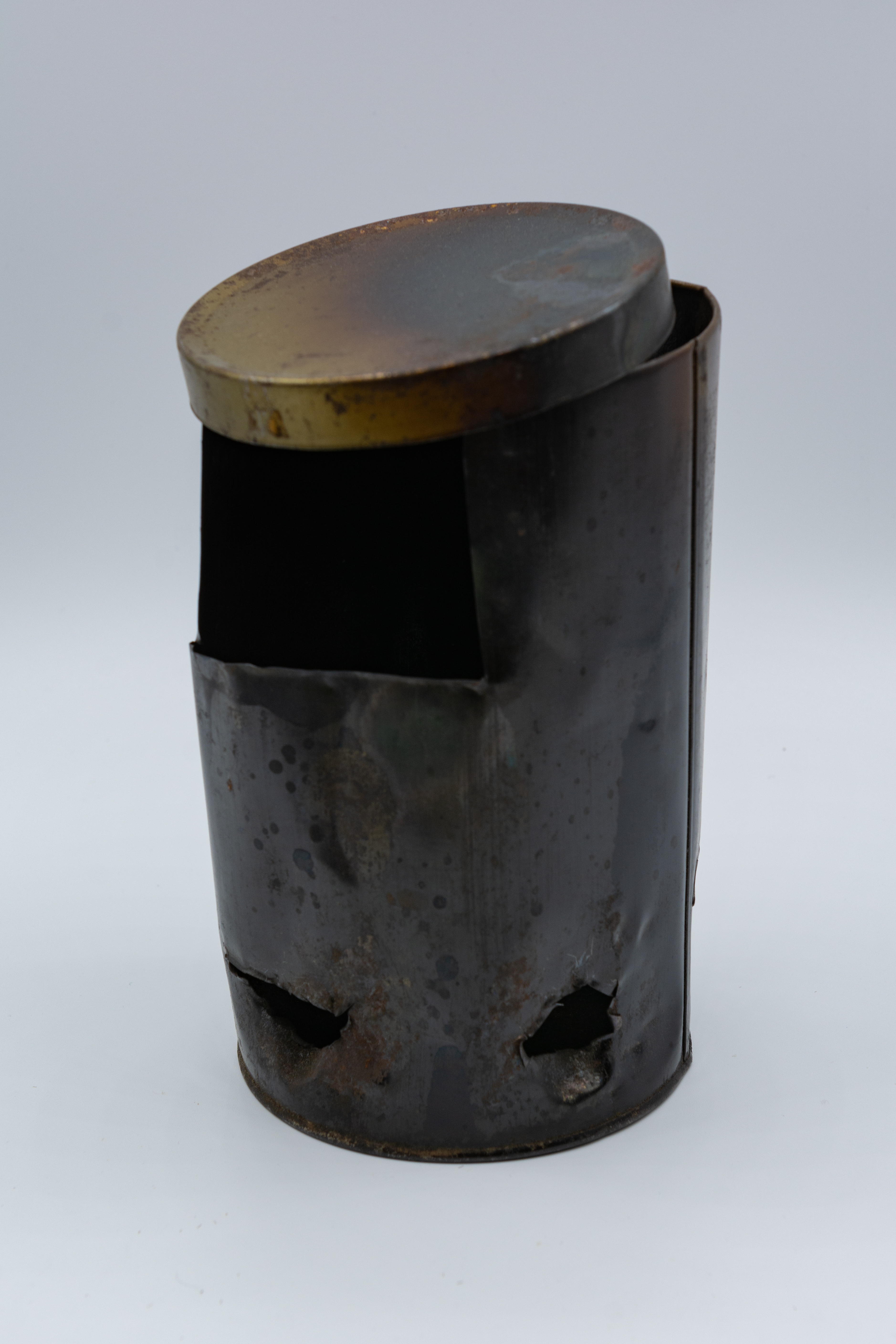 Metal can shaped light with lid with small holes in the bottom and a larger hole at the top