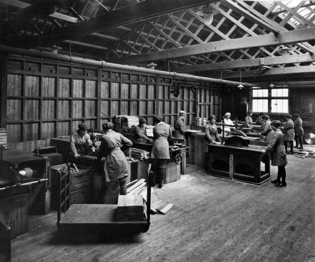 Photograph of female factory workers making box lids.