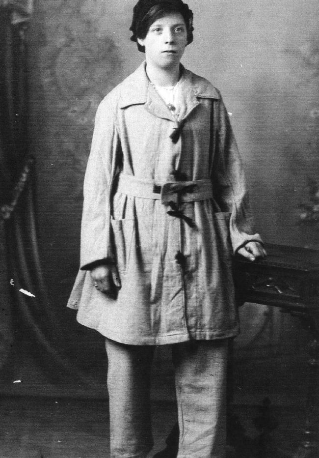 Black and white photograph of woman in factory overalls