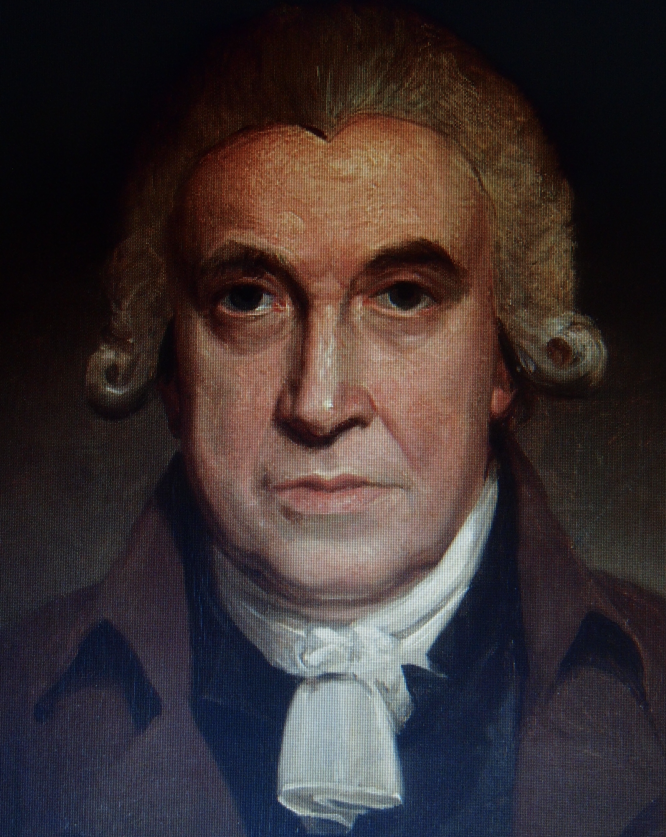 Portrait of a man wearing a wool wig and a white neckchief.  He has dark brown eyes and looks directly out of the painting and at the viewer.