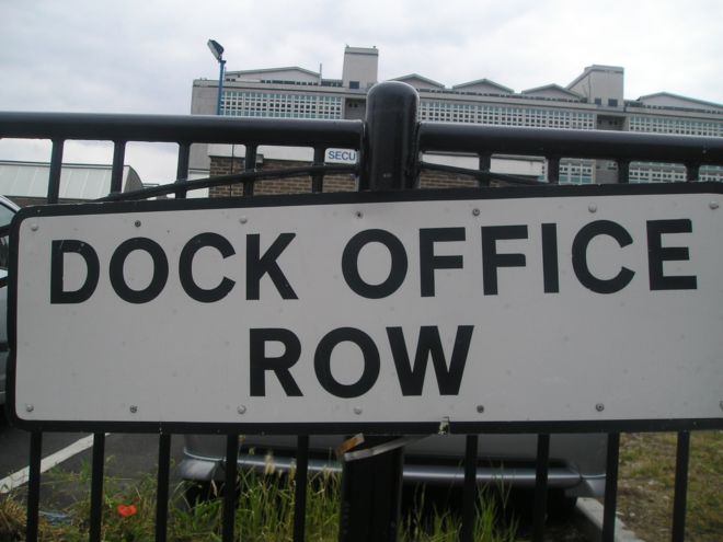 Black and white street sign with the words 'Dock Office Row'