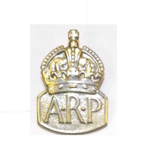 Silvery gold coloured metal badge of a crown and underneath the letters A R P
