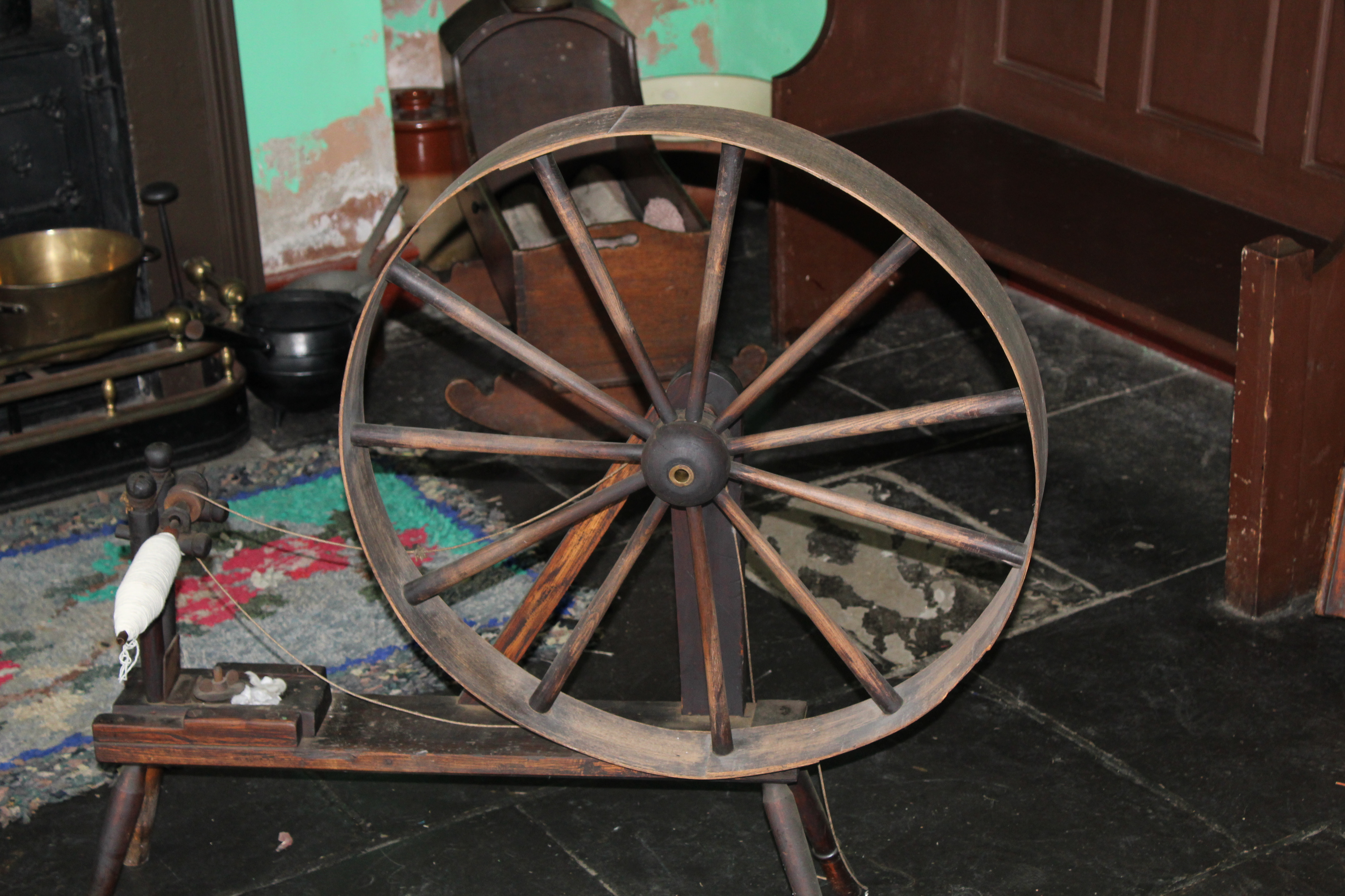 Large wheel mounted on a frame used for spinning wool into yarn ready for weaving.