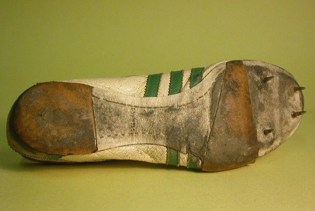 Sole of the shoe showing rubber on the heel  and toe area (but not the arch) and four spikes in the toe area