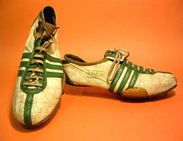 White shoes with three green stripes on each side and a green stripe running down the middle of the toe.