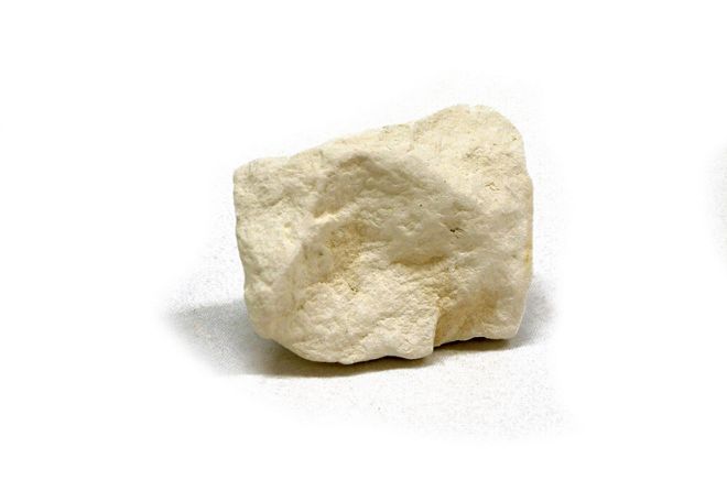 Piece of chalk, white in colour with smoothed angles