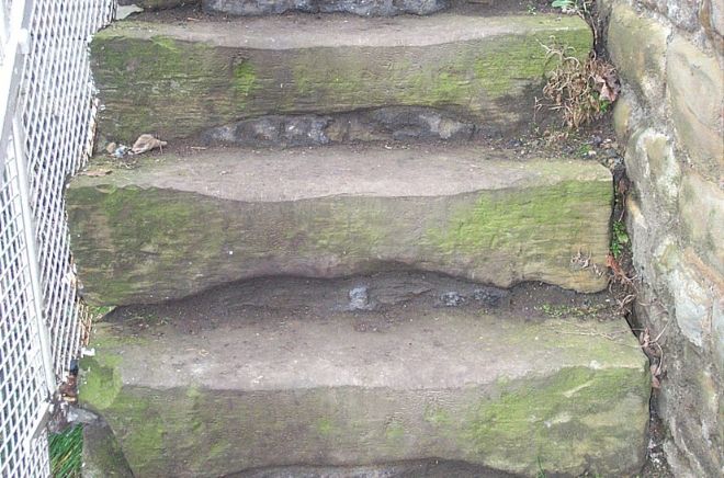 Steps have been worn away in the middle, where people have stepped over the years.