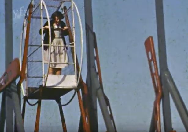 Colour film still showing a young girl in a ride
