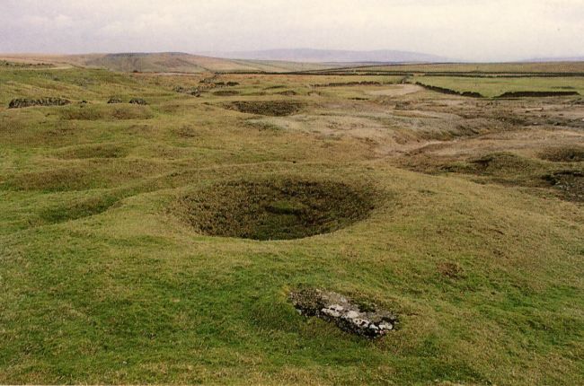 Circular grassy hollows in open industrially scarred moorland
