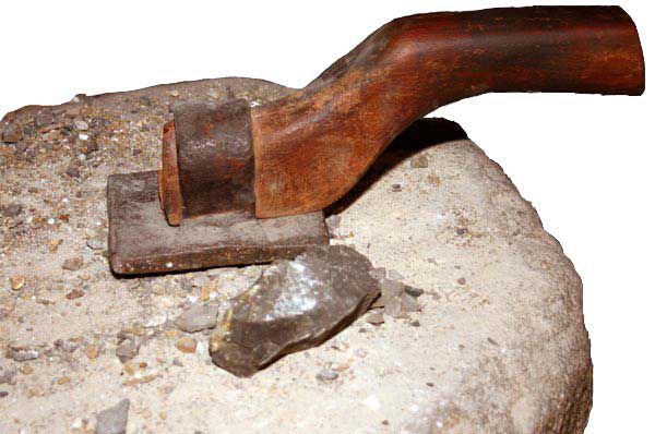 Flat iron block with a short wooden handle with small pieces of Galena rich bouse