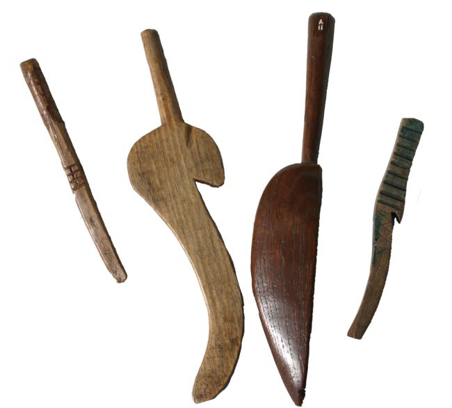 Wooden knitting sticks in various shapes. Two of the four have a broad, flat end to them, a bit like a pallette knife.