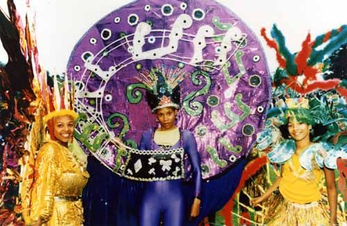 view of three young people in their carnival creations at the Leeds West Indian Carnival. a variety of materials, including sequinned fabrics and feathers, have been used to create these vibrant costumes.