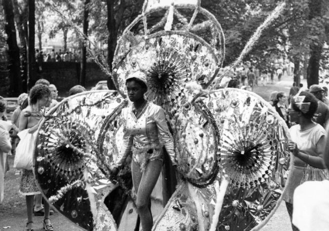 Young girl wearing an exotic costume with 'wings' either side and above her head.