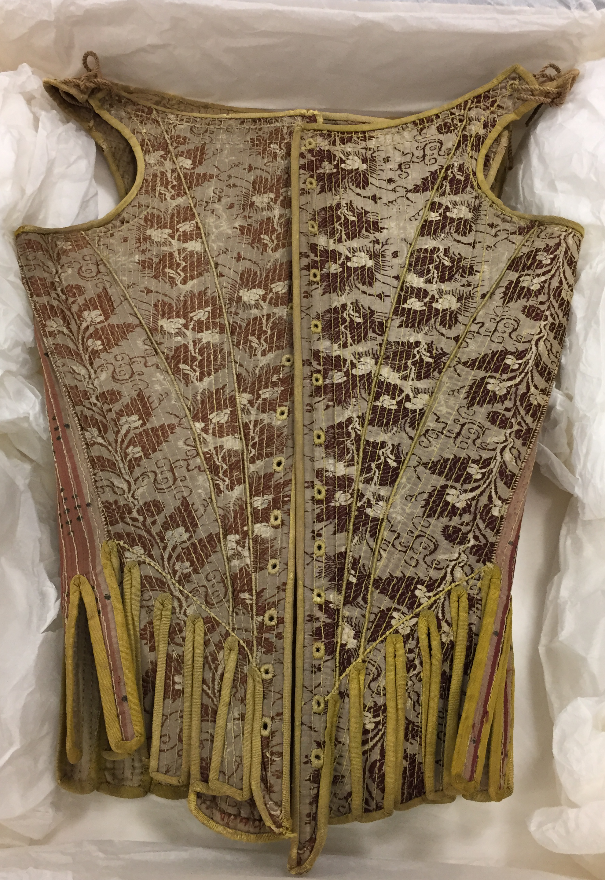 Pair of stays in storage box. One side is a lighter brown than the other.