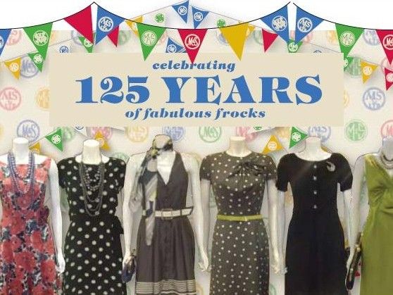 Window display with decorative bunting and mannequins wearing dresses