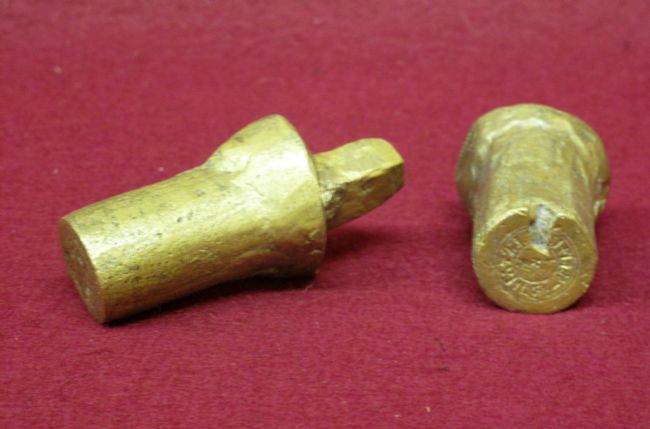 The coin stamp in two halves, showing the design engraved into one half.