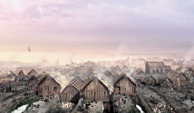 Wooden houses with  thatched roofs, built closely together.  Smoke is coming from the houses.