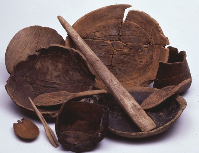 A collection of wooden items showing various degrees of damage.  Bowls of different sizes, cups and spoons.