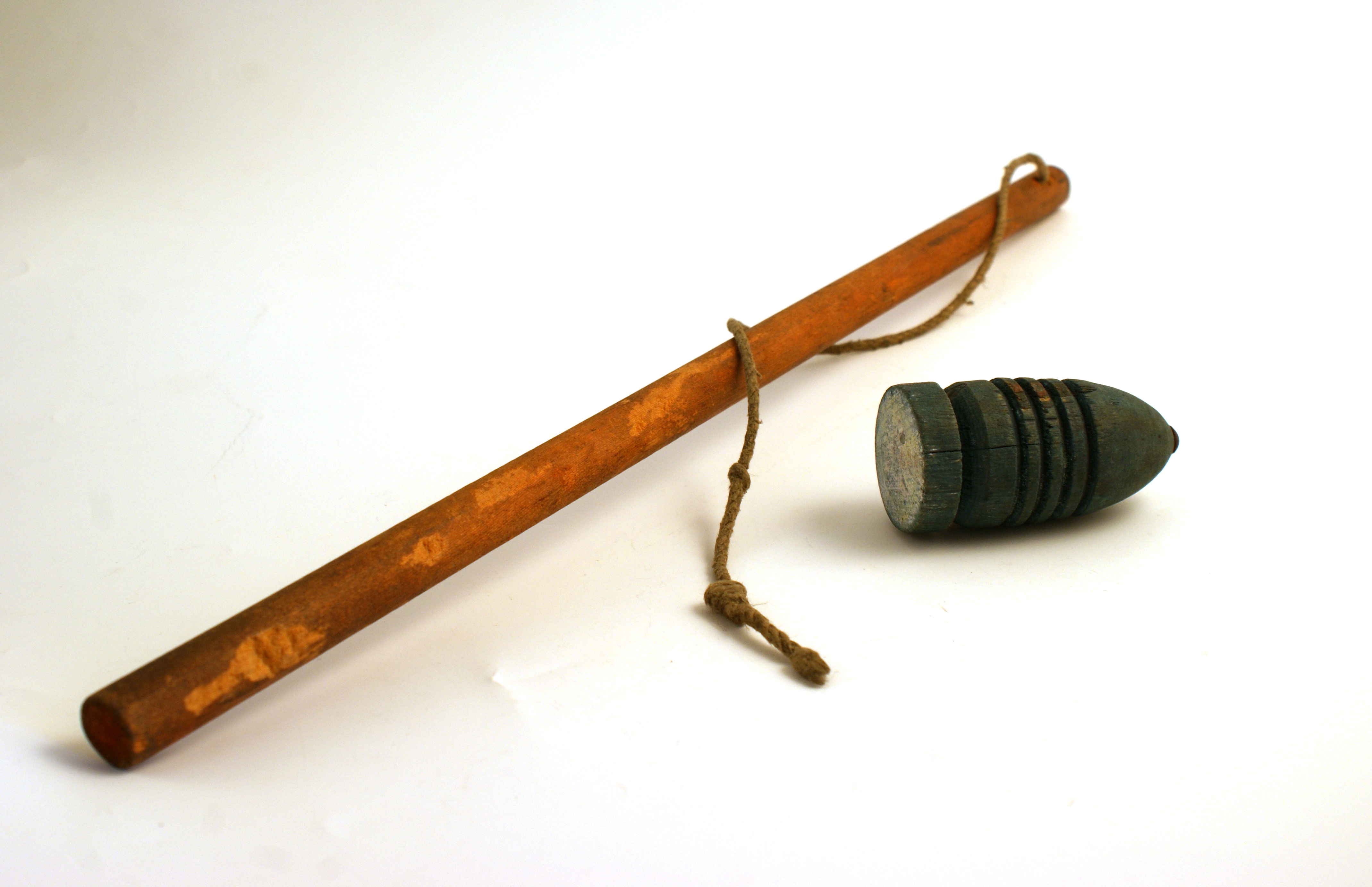 Whip and top consisting of a wooden stick with a string tied to the end and a wooden spinning top.