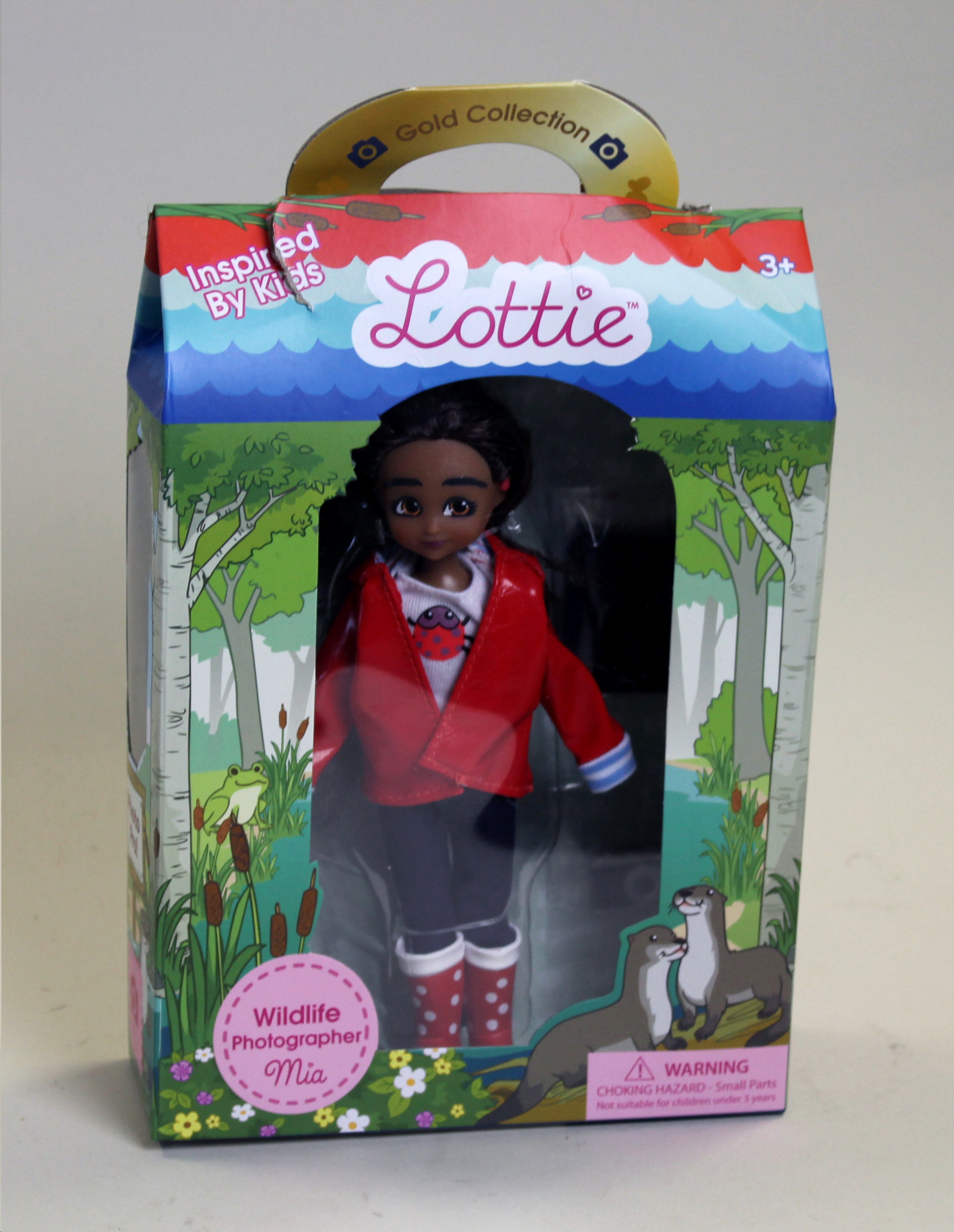 Colour photograph of a Black doll wearing a red jacket, jeans and wellington boots.