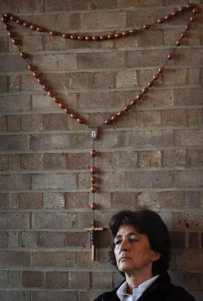 Elzbieta in the Polish parish church in Melton Mowbray in 2008.  She is standing underneath a wall mounted rosary