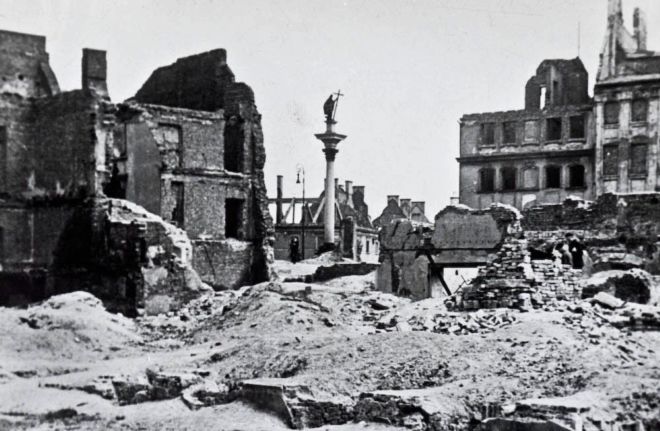 Ruined buildings in Warsaw at the end of World War 2.  The foreground is just piles of rubble, the background is ruined, bombed out buildings
