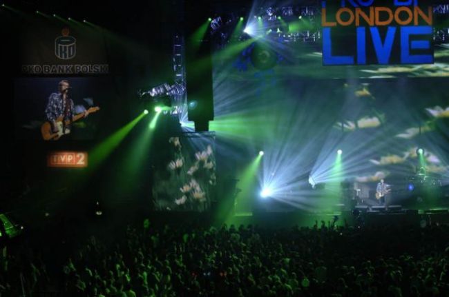 Festival scene with crowds of people and green and white lights