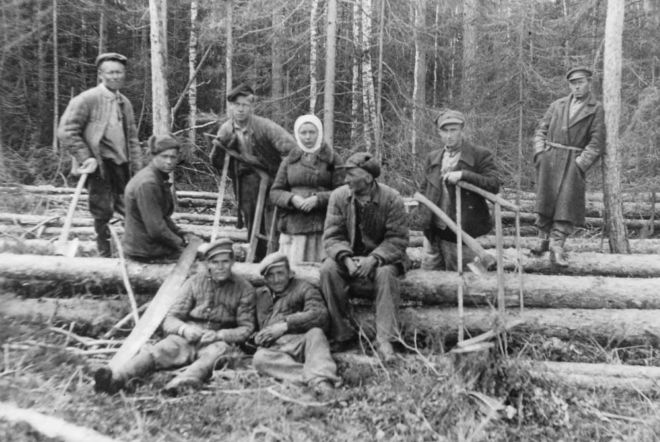 Black and white photograph showing a group of Polish deportees cut timber in a Siberian labour camp, 1940