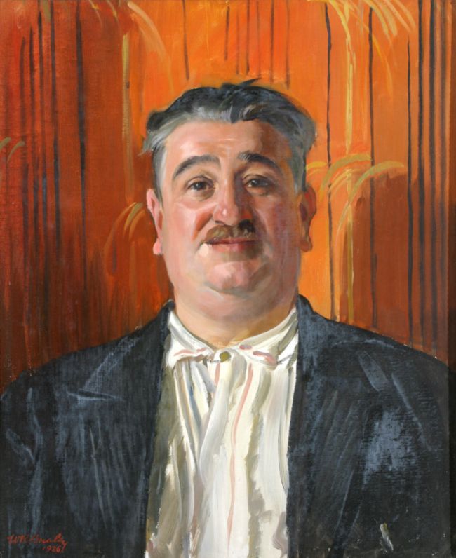 Portrait showing head and shoulders of a man with a moustache and short grey hair. He wears a white shirt with a dark blue jacket and stands against a bright orange background.