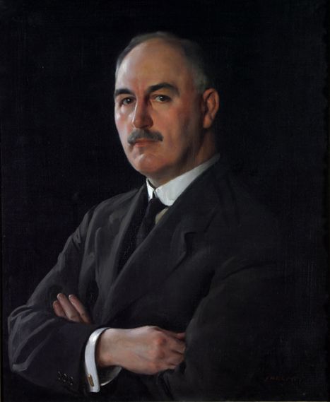 Portrait of J. G. Graves by David Jagger, of a middle aged gentleman with his arms folded and wearing a dark suit. The man stands at an angle with his head turned towards the viewer, his face showing a serious expression.