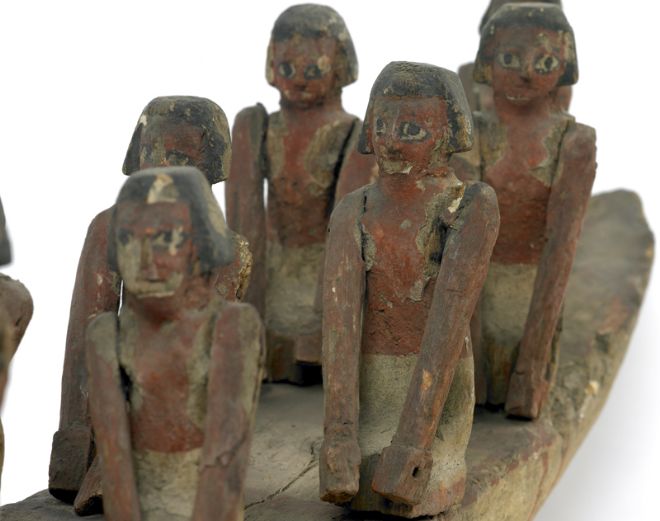 Close up image of the pairs of rowers, their faces are still very distinct.  They have black painted hair and black and white painted eyes.