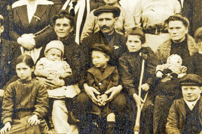 Close up showing many children from the main photograph, including a boy with a crutch