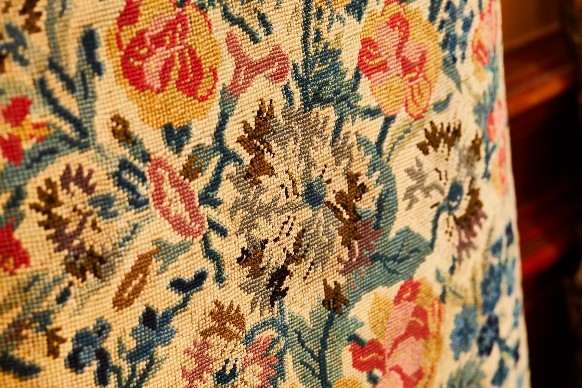 Close up colour photograph of the embroidered chair showing a design of flowers.