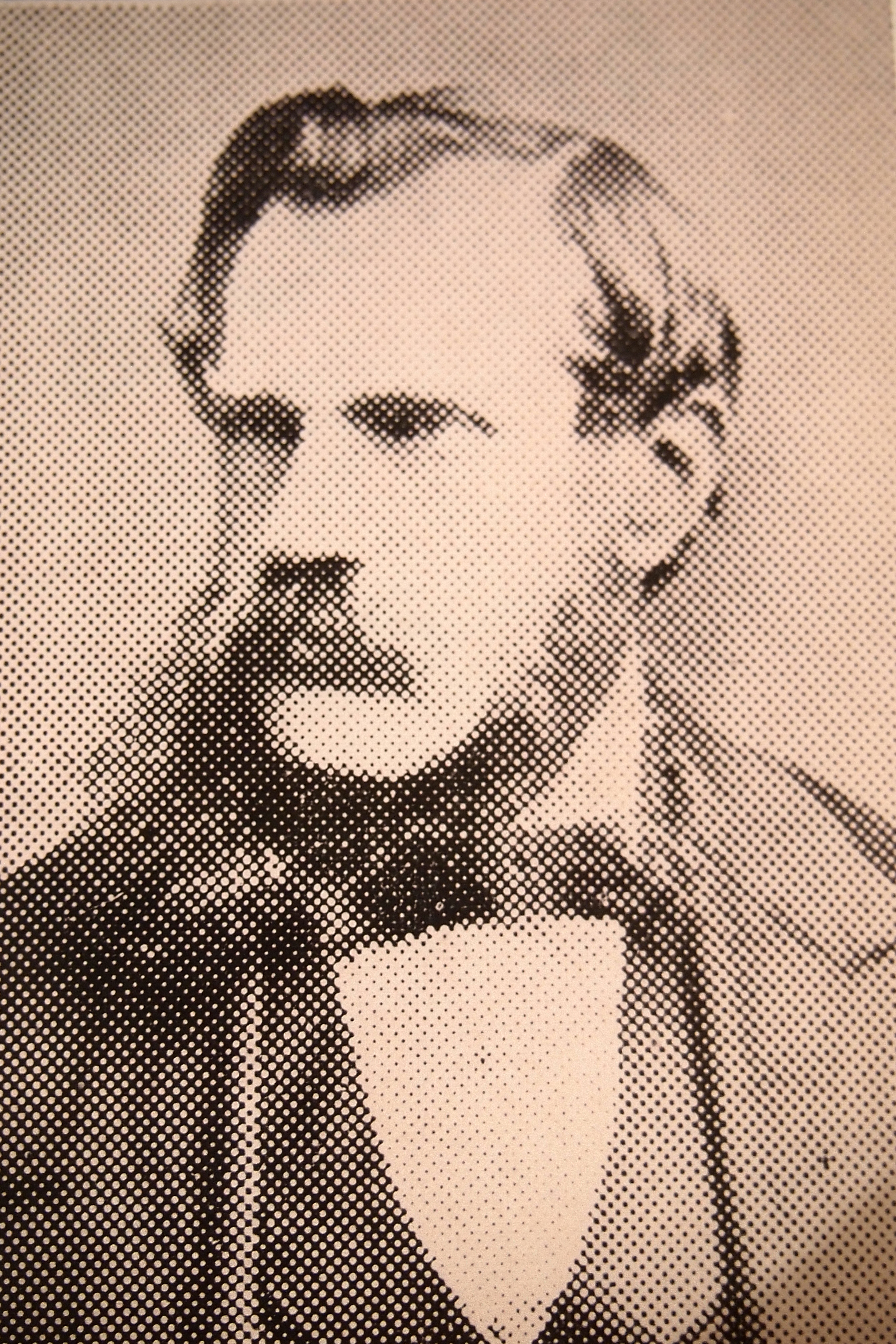 Black and white dot portrait of a man with a moustache.  He is wearing a dinner jacket and bow tie