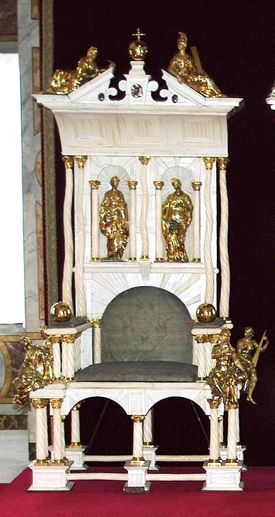 Colour photograph showing a white and gold throne. Many narwhal tusks can be seen running both vertically and horizontally in the design.