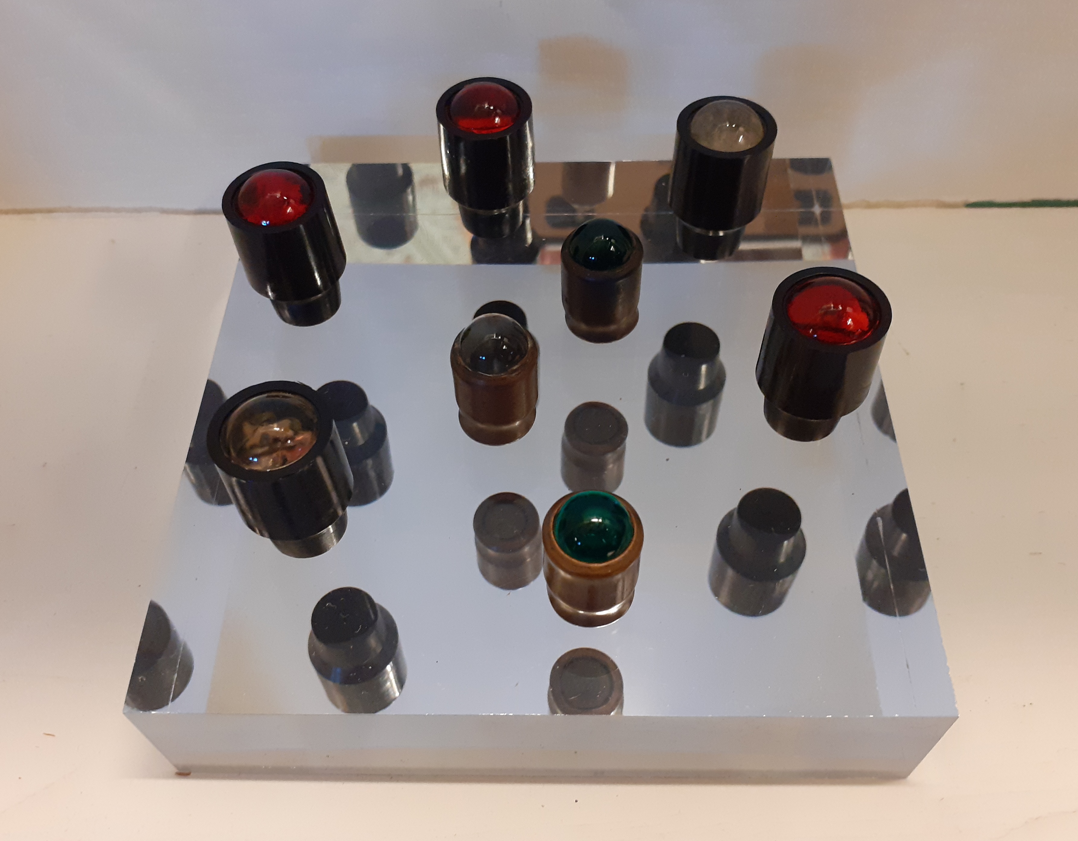 Colour photograph showing a range of bulbs in blue, white and red, for use in road catseyes