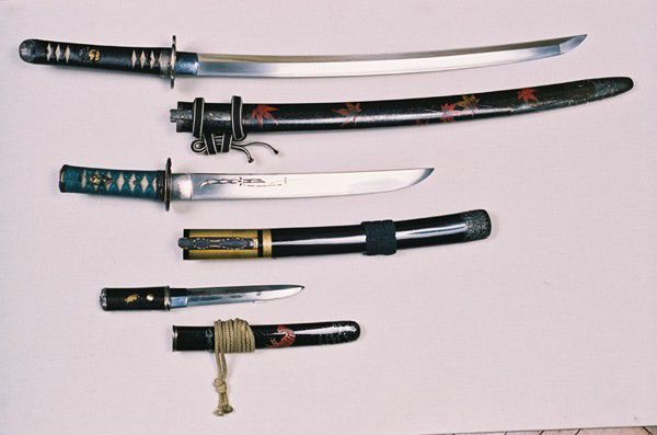 A samurai long sword, short sword and dagger. The sheaths are made of lacquered wood with designs on.