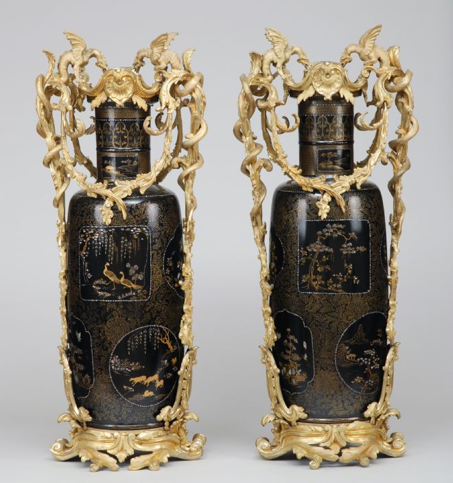 Brown vases with intricate gold handles  of leafy vines and winged beasts.