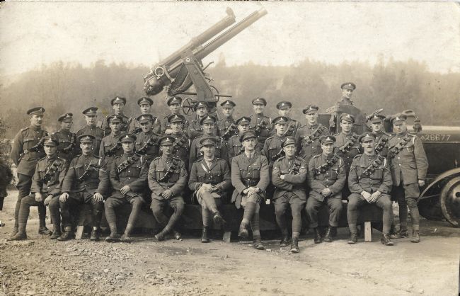 Photo showing an anti-aircraft gun in the background, with British soldiers in the foreground
