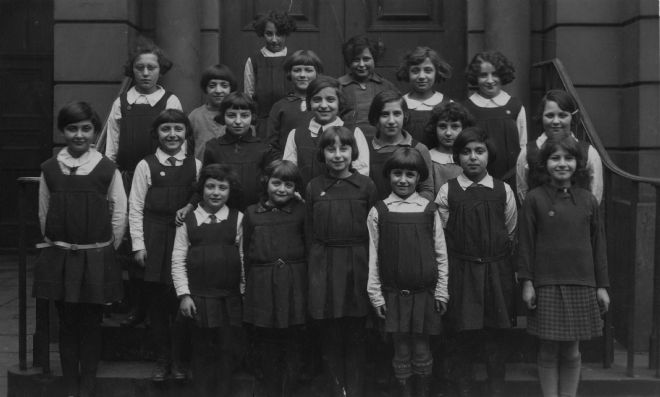 Black and white photograph showing pupils from Hull Hebrew Girls School.  They are wearing dark coloured skirts and jumpers or pinafores with white shirts.