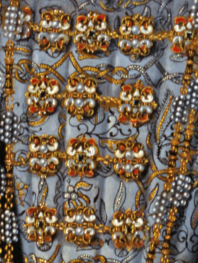 Close up of the dress, showing an elaborate pattern of pearls and gold thread embroidery.