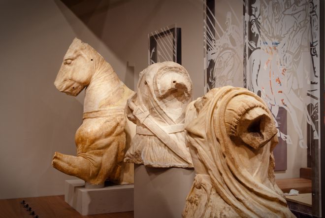 Three large marble Roman statues known as the 'Lanuvium marbles'. One is part of a horse and the other two are the torsos of Roman men.