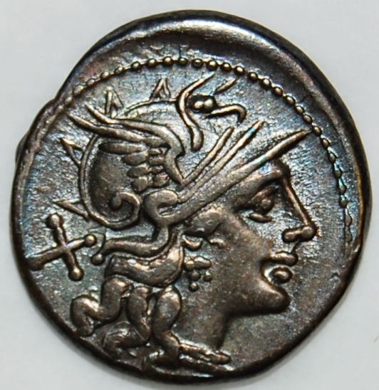 An old metal Roman coin showing a head of a Roman man with a helmet