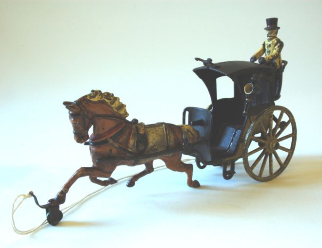 Victorian pull-along toy Hansom Cab pulled by horse.  The cab is black and there is a footman standing on the back.  The hose is brown with a golden mane.