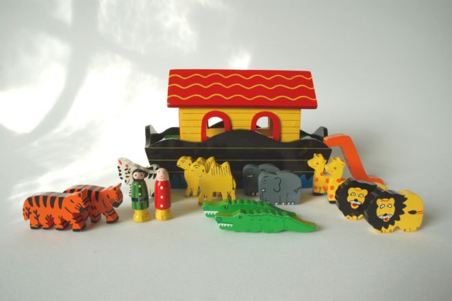 A new Noah´s Ark toy made of wood and brightly painted.  There are pairs of tigers, zebras, camels, crocodiles, elephants, giraffes and lions as well as two human figures.